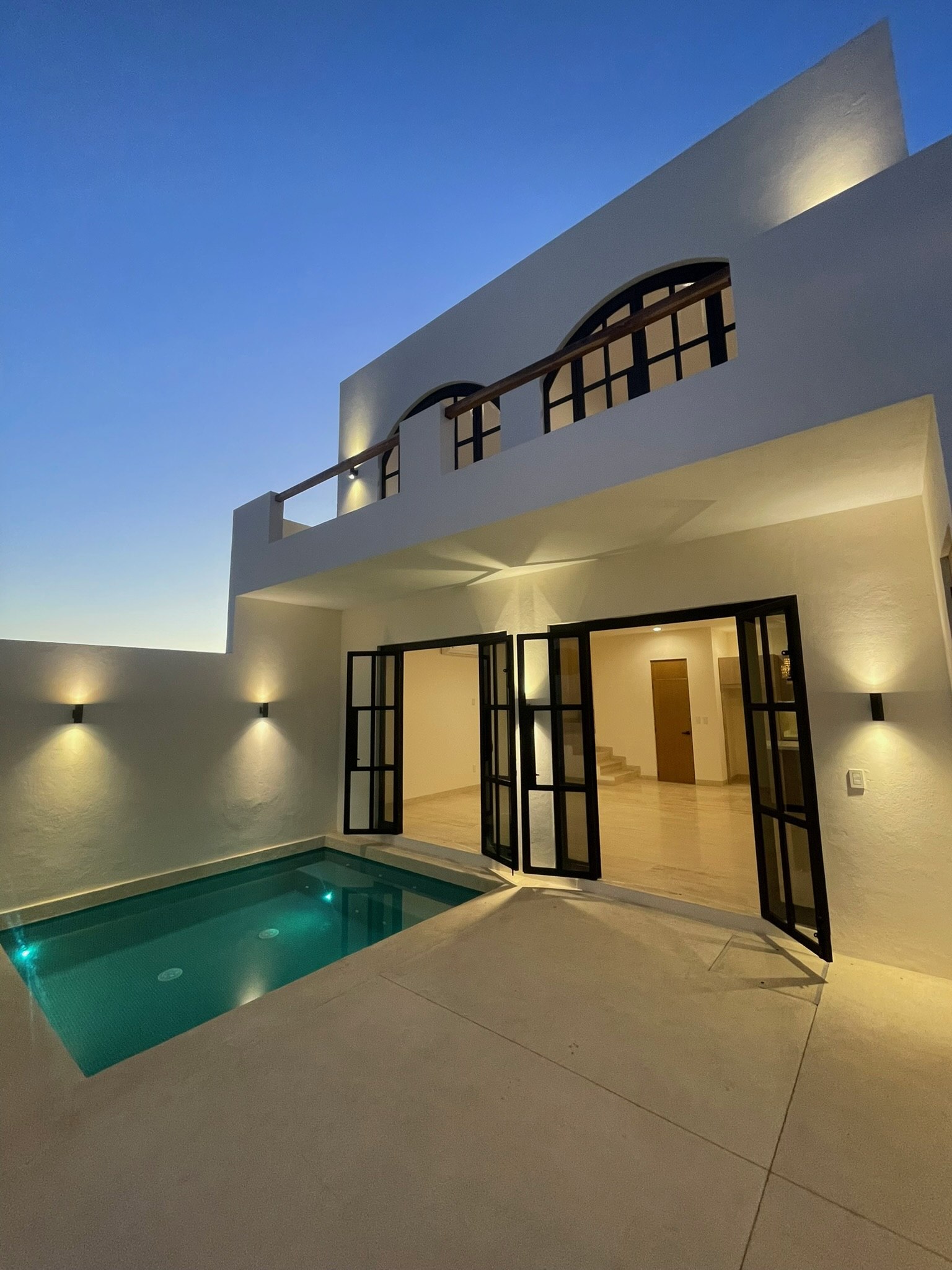 Courtyard pool and steel doors at twilight