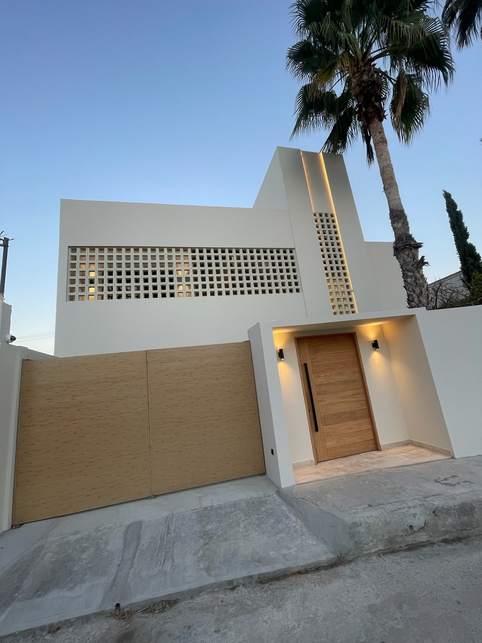 Perforated concrete screen facade at dusk